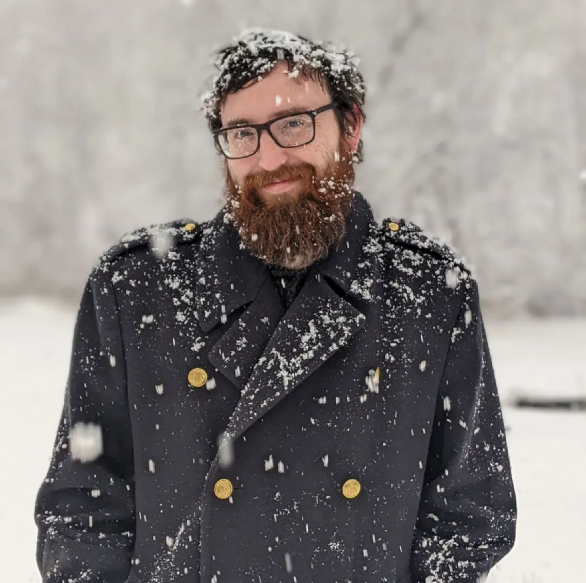 Vander Gac, Communications Coordinator, smiling in a snowstorm