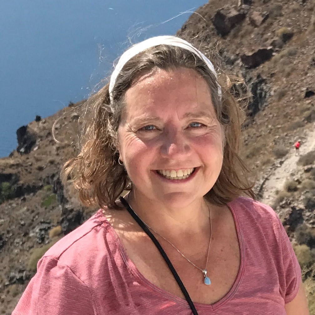 Grant Coordinator Candice Huber smiling with rocks and water behind her