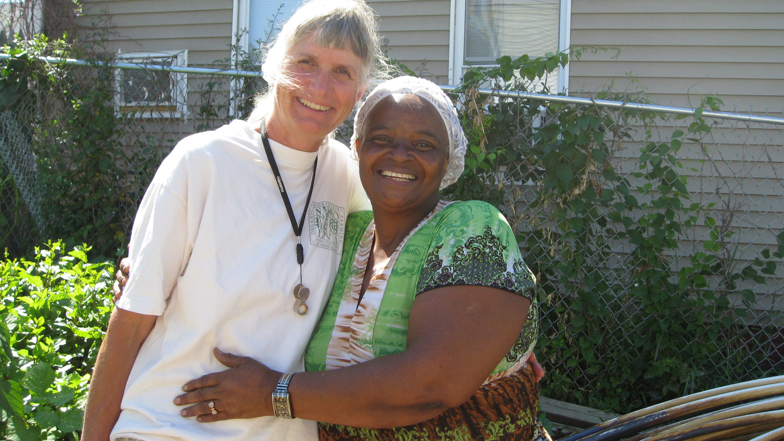 Two women hugging outside of a house