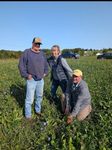 three people in a field of cover crops