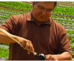 A man using a tool in the middle of a farm field